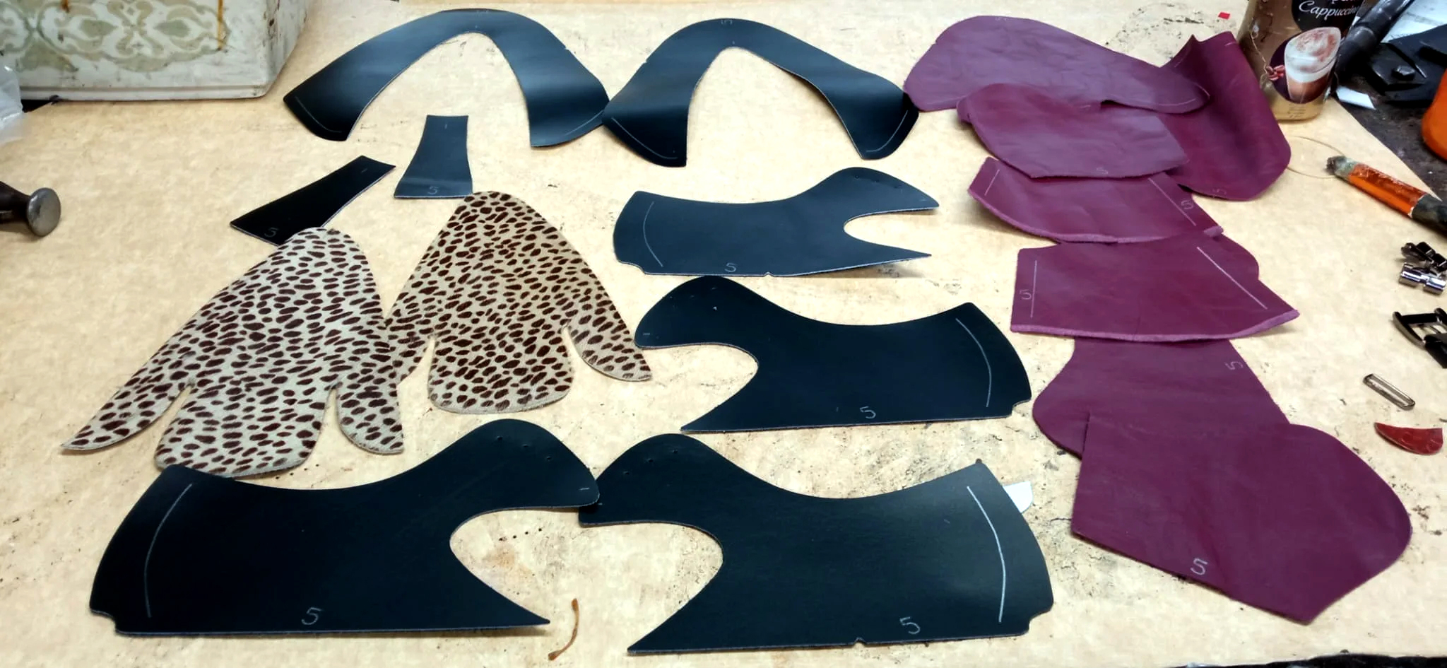 Individually cut leather pieces prepared for the construction of a pair of creepers