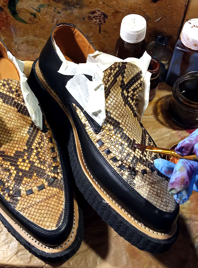 Hand applying a custom patina to genuine python Creepers
